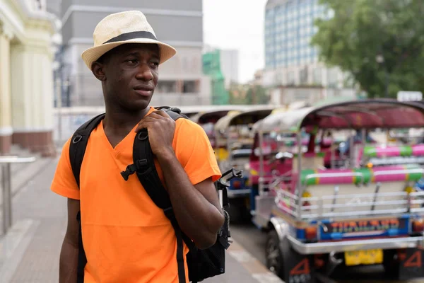 Африканський туристичних людина мисляча утримуючи рюкзак в Бангкоку — стокове фото
