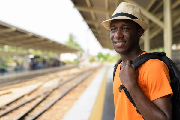 Face of African tourist man smiling and waiting train