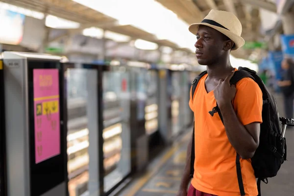 Young black African tourist man at train station