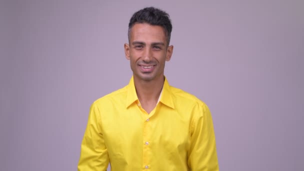Молодой счастливый персидский бизнесмен в желтой рубашке улыбается — стоковое видео