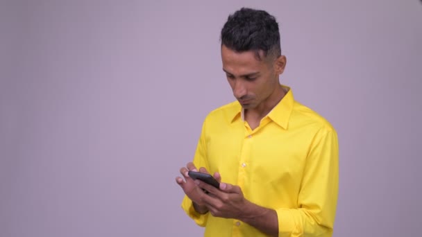 Молодой красивый персидский бизнесмен в жёлтой рубашке с телефоном — стоковое видео