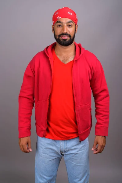 Porträtt av ung stilig indiska man klädd i röd tröja — Stockfoto