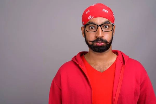 Gelangweilte indische Mann trägt rotes Hemd und macht lustiges Gesicht — Stockfoto