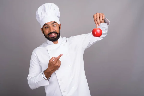 Joven guapo indio hombre chef celebración de manzana —  Fotos de Stock
