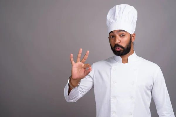 Young handsome Indian man chef making OK sign — стокове фото