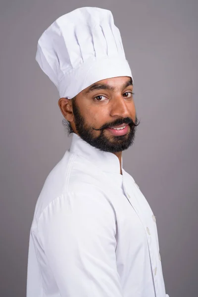 Молодий індійський кухар на сірому фоні. — стокове фото