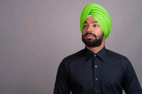 Young Indian Sikh businessman wearing green turban — Stock fotografie