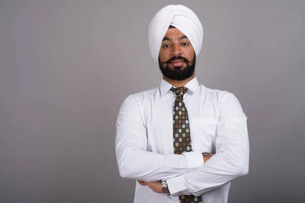 Jeune bel homme d'affaires indien sikh portant turban contre gr — Photo