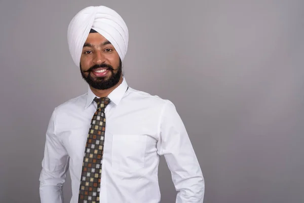 Giovane bell'uomo d'affari indiano Sikh indossa turbante contro gr — Foto Stock