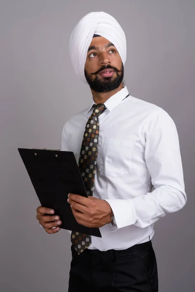 Jeune bel homme d'affaires indien sikh portant turban contre gr — Photo