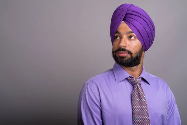 Mladý pohledný podnikatel indická Sikh nosí turban proti gr — Stock fotografie