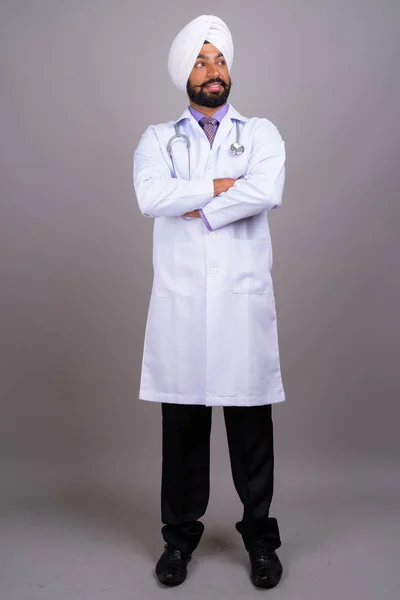 Retrato de jovem indiano Sikh homem médico sorrindo e pensando — Fotografia de Stock