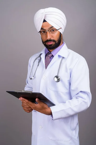 Portrait of young Indian Sikh man doctor holding clipboard — Stock Photo, Image