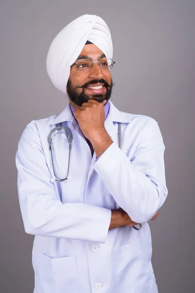 Indiano sikh homem médico pensando e sorrindo — Fotografia de Stock