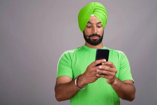 Jeune beau indien sikh homme textos avec téléphone mobile — Photo