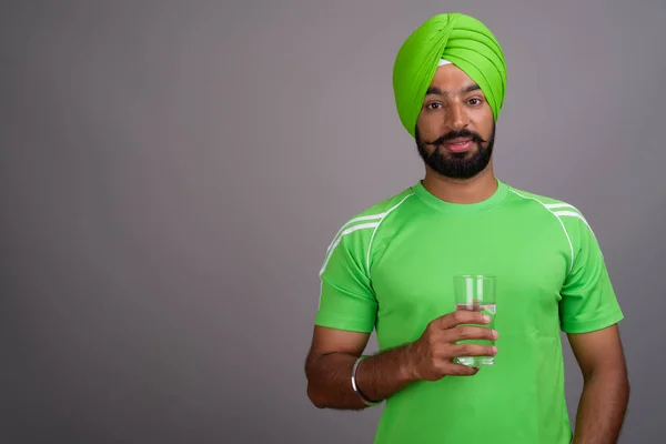 Giovane bel Sikh indiano che indossa turbante e camicia verde — Foto Stock