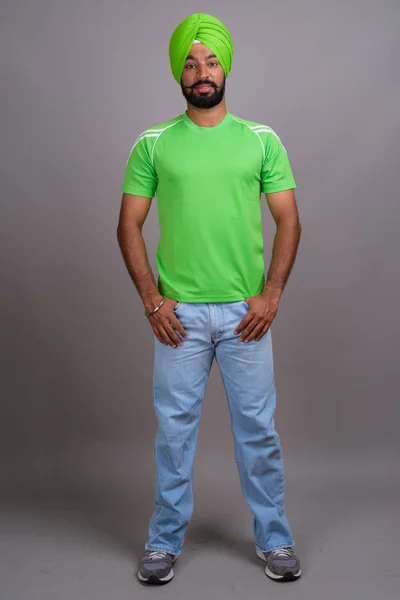 Jovem bonito indiana sikh homem vestindo turbante e verde camisa — Fotografia de Stock