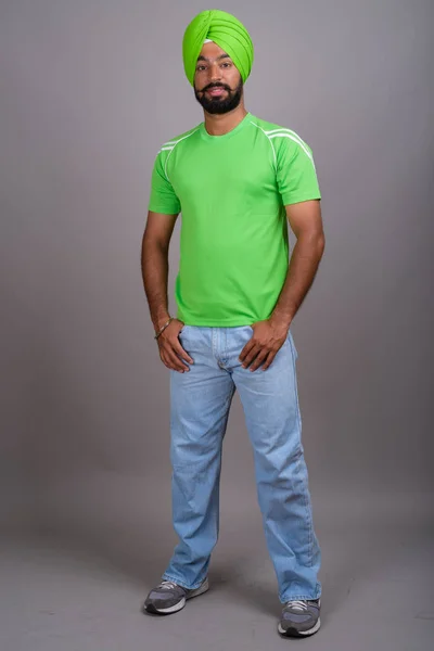 Jovem bonito indiana sikh homem vestindo turbante e verde camisa — Fotografia de Stock