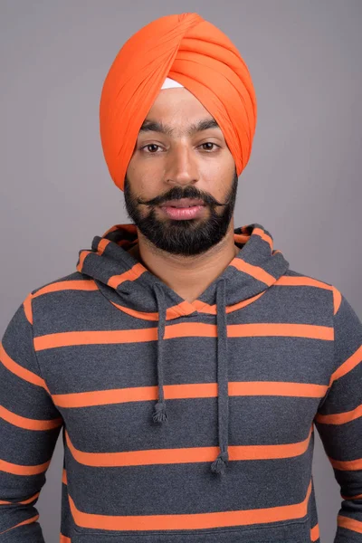 Joven hombre sikh indio guapo usando turbante naranja — Foto de Stock