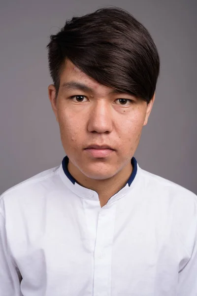 Молодой азиатский подросток на сером фоне — стоковое фото