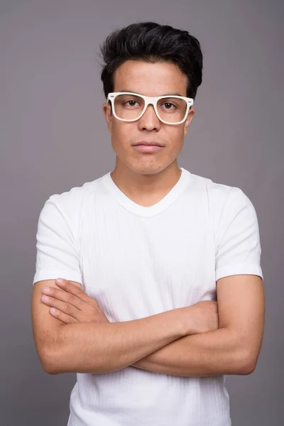 Portrait of young Asian man against gray background — Stock Photo, Image