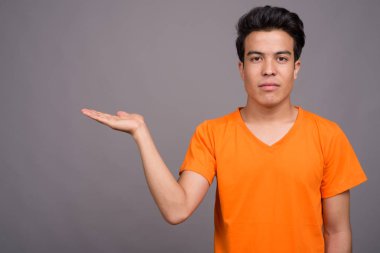 Gri arka planda Asyalı genç bir adamın portresi