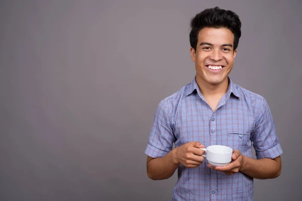 Retrato de jovem empresário asiático contra fundo cinza — Fotografia de Stock