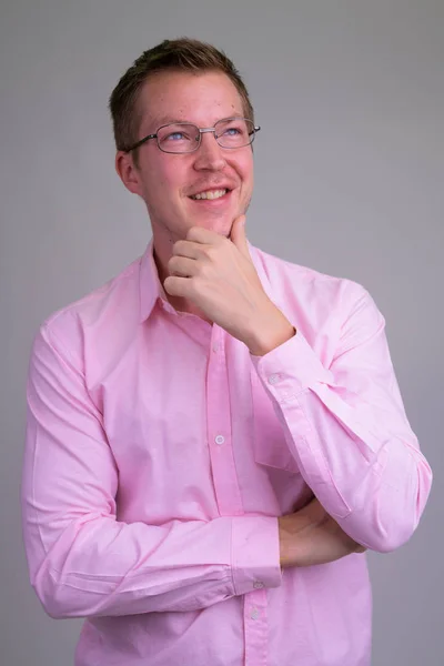 Porträtt av ung glad affärsman med glasögon tänkande — Stockfoto