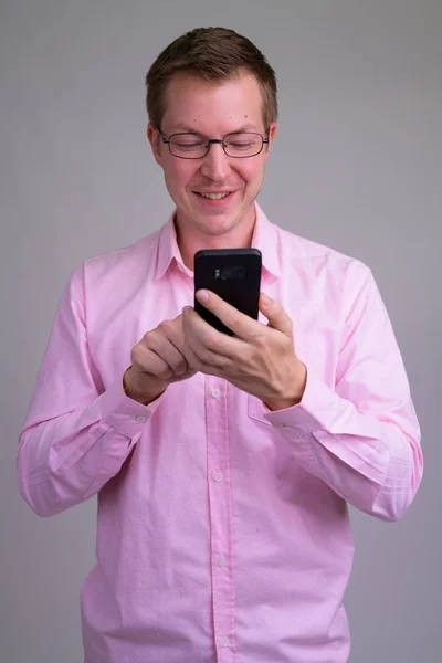 Young happy businessman using phone with eyeglasses — Stock Photo, Image