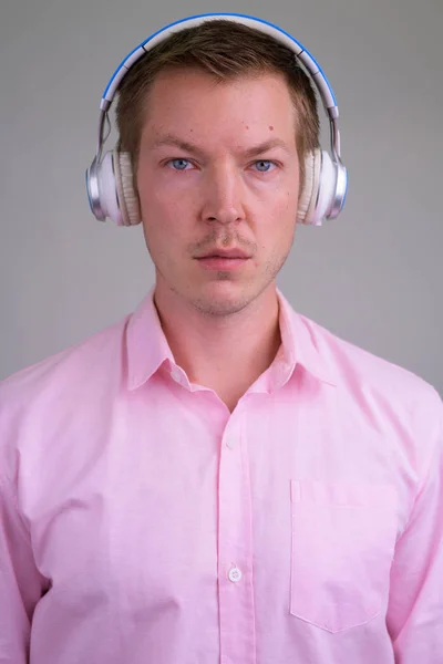 Rostro de joven hombre de negocios guapo escuchando música — Foto de Stock