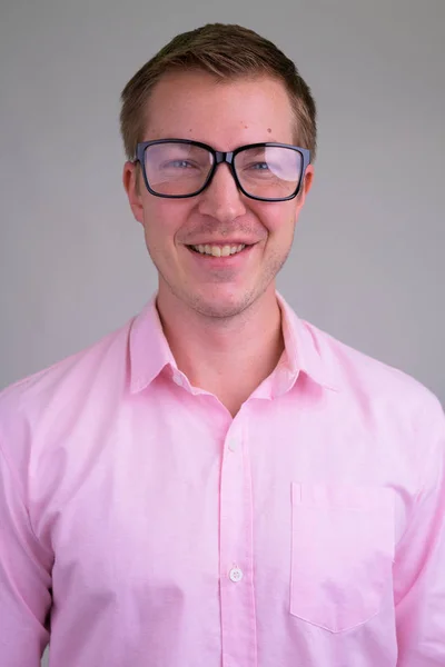 Gezicht van jonge gelukkig nerd zakenman glimlachend met bril — Stockfoto