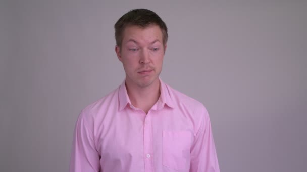 Face of stressed young businessman giving thumbs down — Stock Video