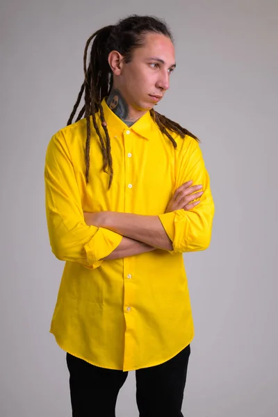 Junger Geschäftsmann mit Dreadlocks, die Arme und Denken kreuzen — Stockfoto