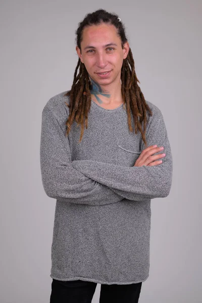 Portrait of happy young man with dreadlocks smiling while crossing arms — Stock Photo, Image