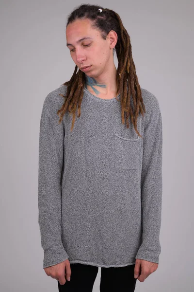 Portrait of sad young man with dreadlocks thinking and looking down — Stock Photo, Image