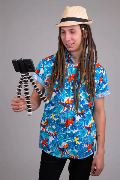 Gelukkig jonge toeristische man met dreadlocks vlogging met telefoon — Stockfoto