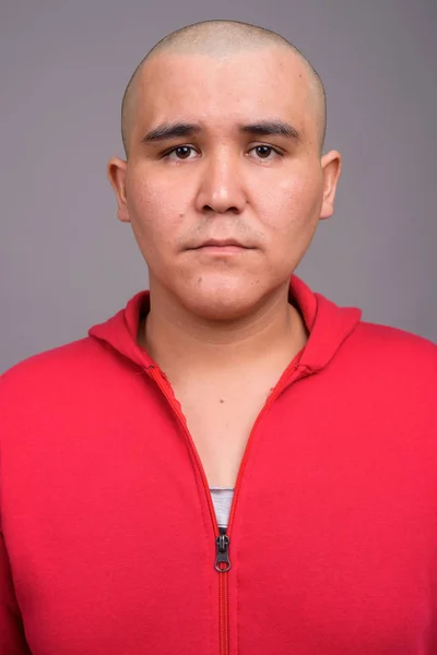 Joven calvo asiático hombre contra gris fondo —  Fotos de Stock