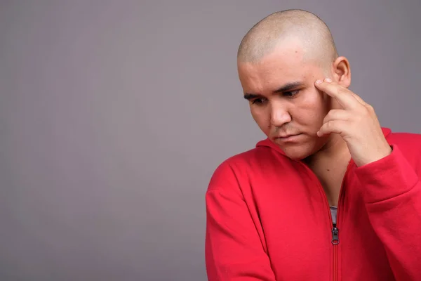 Jovem careca Asiático homem contra fundo cinza — Fotografia de Stock