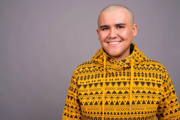 Joven calvo asiático hombre contra gris fondo —  Fotos de Stock