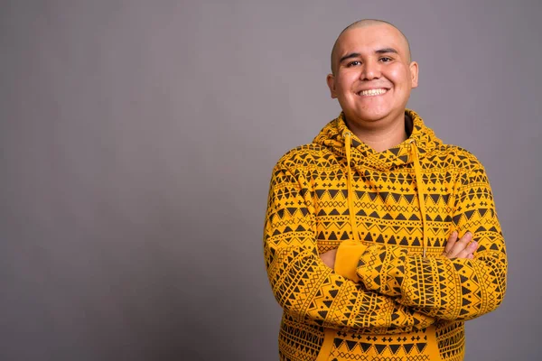 Jovem careca Asiático homem contra fundo cinza — Fotografia de Stock