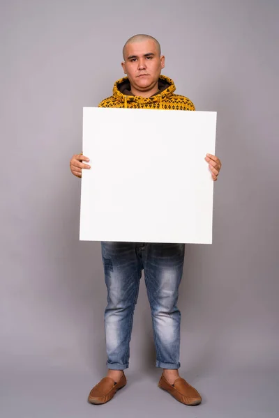 Jonge kale Aziatische man tegen grijze achtergrond — Stockfoto