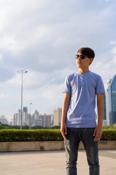 Młody chłopiec azjatyckich nastoletnich noszenie okularów przeciwsłonecznych podczas relaksu przy — Zdjęcie stockowe