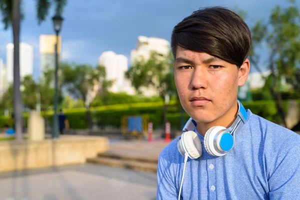 Νεαρά ασιατικές εφήβου φορώντας ακουστικά ενώ χαλαρώνετε στο το — Φωτογραφία Αρχείου