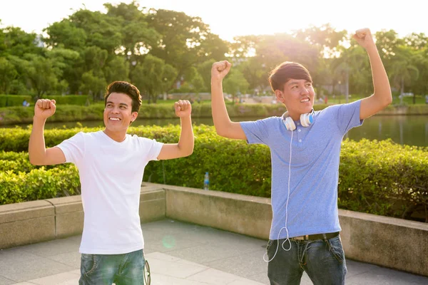 Jovem homem asiático e jovem adolescente asiático no parque juntos — Fotografia de Stock