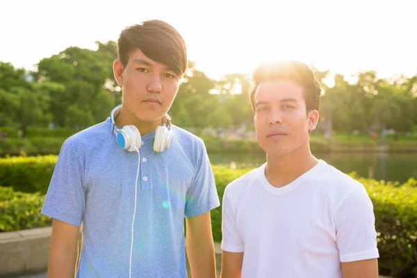 Молодий азіат і молодий хлопець азіатського походження в парку разом. — стокове фото