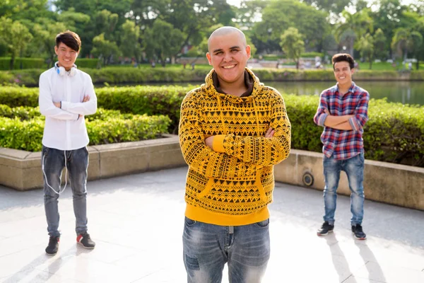 Trois jeunes hommes asiatiques se relaxant au parc ensemble — Photo