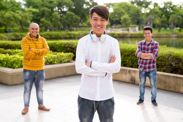 Drie jonge Aziatische mannen ontspannen samen in het park — Stockfoto