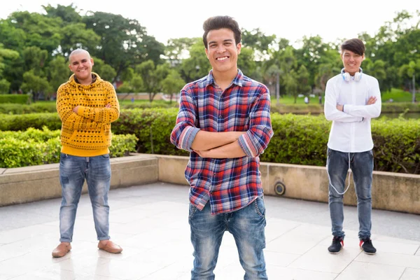 Trois jeunes hommes asiatiques se relaxant au parc ensemble — Photo