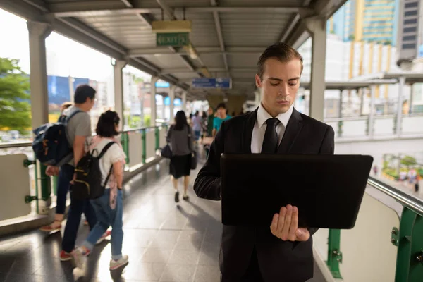 Jonge zakenman laptopcomputer gebruikt in stad — Stockfoto