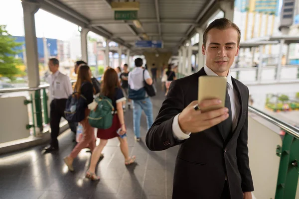 Young businessman using mobile phone in city — Stock Photo, Image